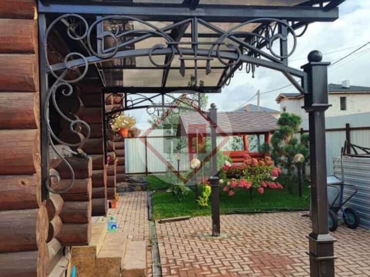 кованый навес для бревенчатого загородного дома